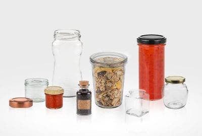 picture of glass jars laid out some empty some with food inside. on a wooden table with a tree background.